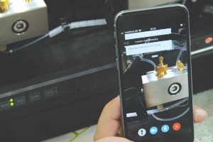 Scientist with smartphone using augmented reality so Unity Lab Services can troubleshoot, diagnose, and possibly repair their scientific instrument remotely